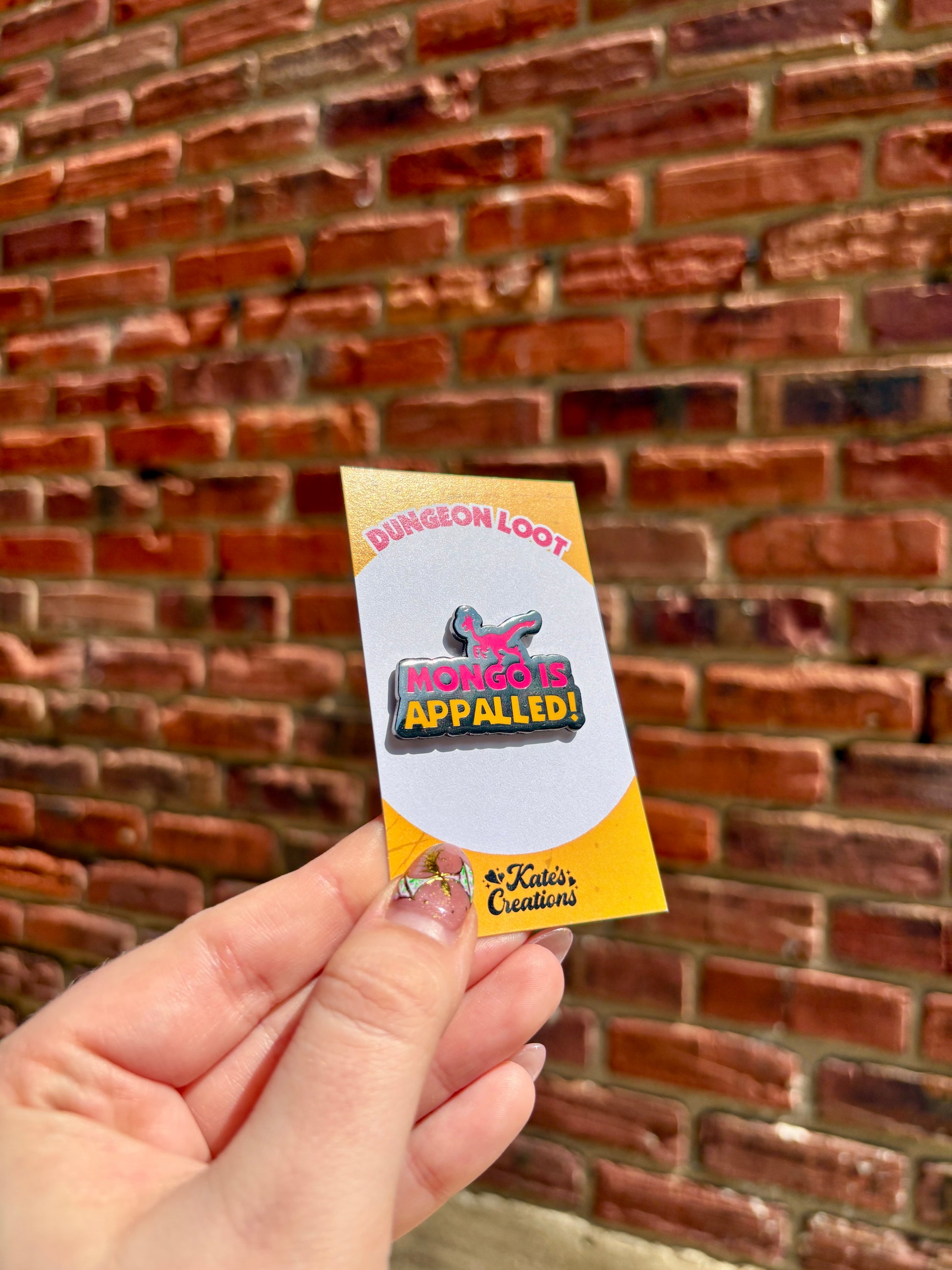 Hand holding a small card with a logo against a brick wall